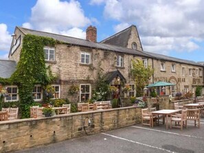 A stone building with a pub named "White Bear Hotel" and outdoor seating. - 2A Bridge Apartments (Ripon)