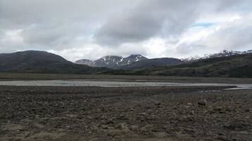 A rocky terrain with a body of water and mountains in the background.