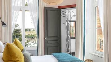 A bedroom with a bed, a view of the outside, and a door to a bathroom.