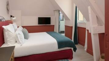 Una habitación de hotel con una cama, televisión y vistas al exterior.