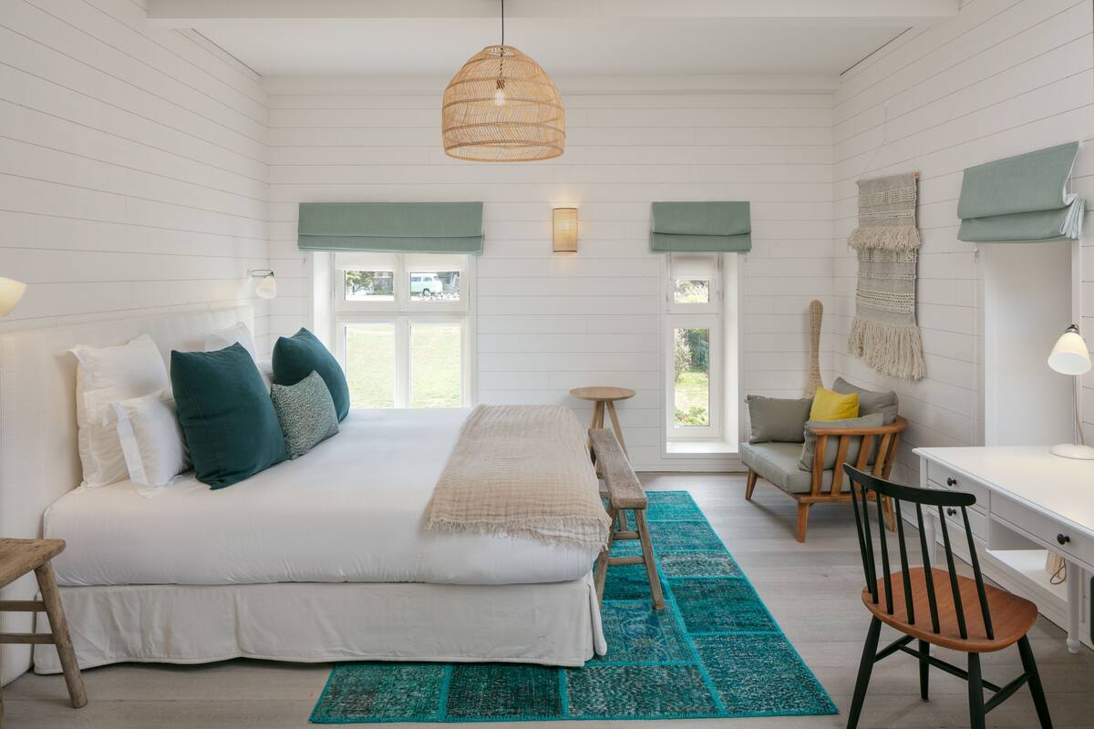 A bedroom with a bed, a desk, and a chair.