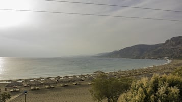 Na praia, espreguiçadeiras, guarda-sóis