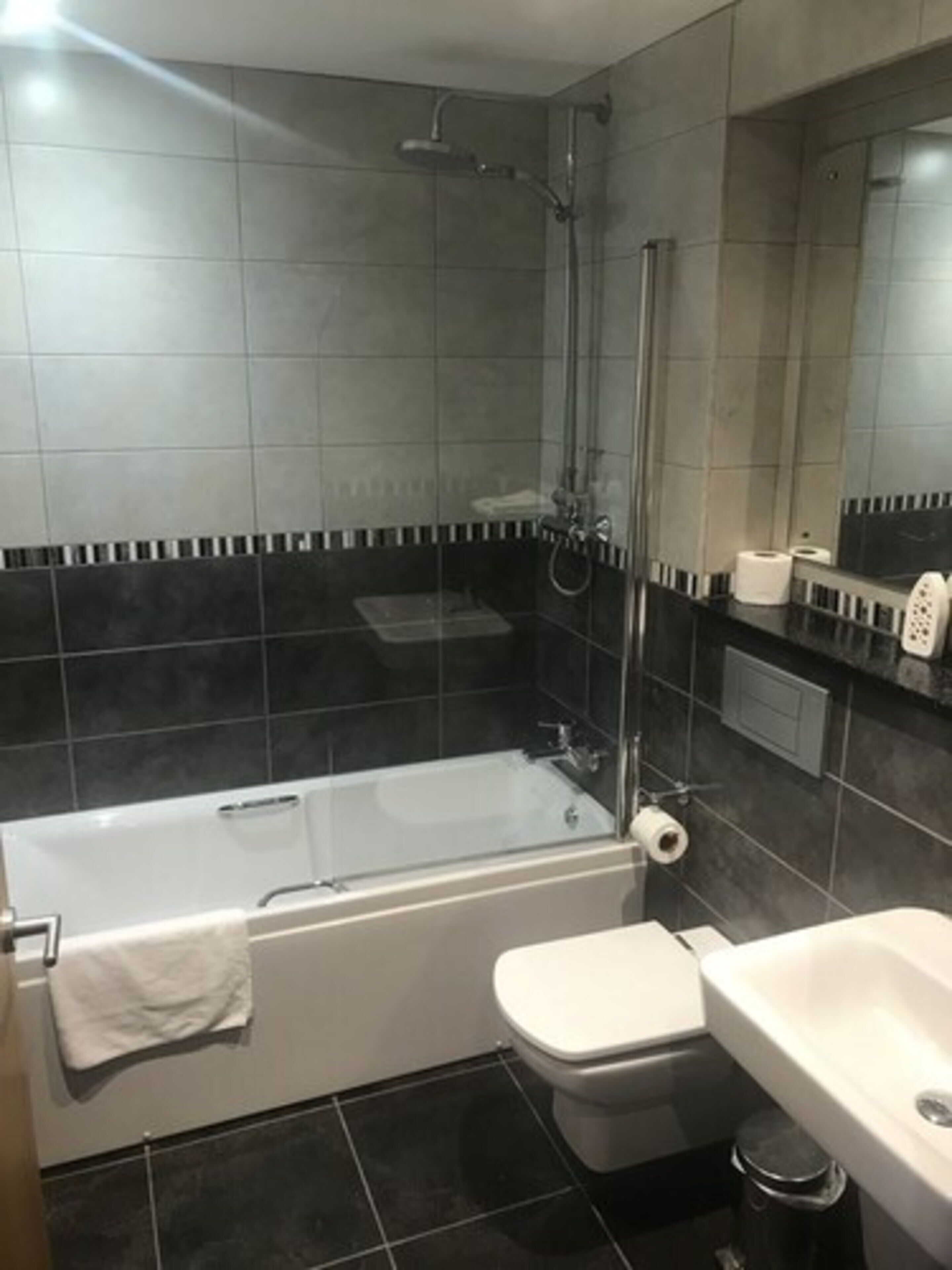 Un baño con bañera, inodoro y lavamanos.