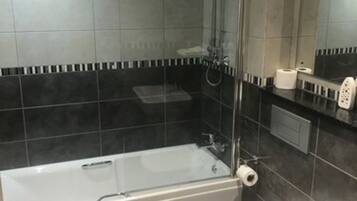 Un baño con bañera, inodoro y lavamanos.