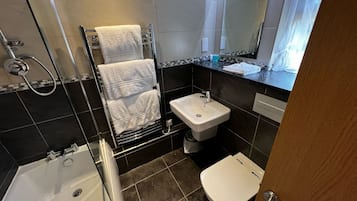 Een moderne badkamer met een bad, een wastafel en een toilet.