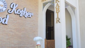 A building with a sign reading "Hotel KABIR" and a "Kosher Food" sign.