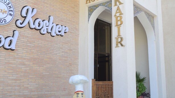 A building with a sign reading "Hotel KABIR" and a "Kosher Food" sign. - Kabir Hotel (Bukhara)