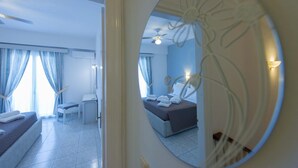 A hotel room with a bed, a desk, and a chair. There is a large mirror on the wall. - Fedra Mare Apartment (Corfu)
