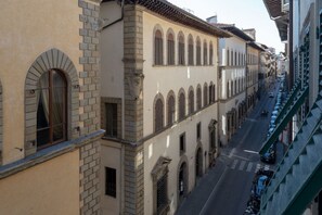 Une rue étroite bordée d’immeubles aux fenêtres en arc de cercle et à la façade en briques.