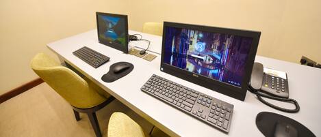 A desk with two monitors, a keyboard, a mouse, and a telephone.