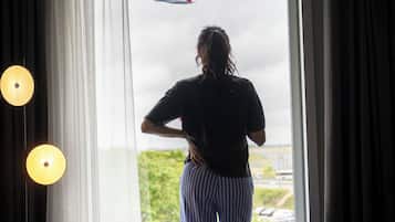 Una persona de pie junto a una ventana con vista a un avión.