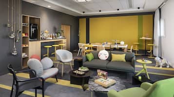 Una sala de estar moderna con un sofá, sillas, una mesa de centro y un comedor con mesa y sillas.