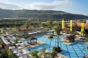 A resort with multiple swimming pools, lounge areas with umbrellas, and a view of a mountainous landscape. - TUI MAGIC LIFE Calabria - All Inclusive (Pizzo)