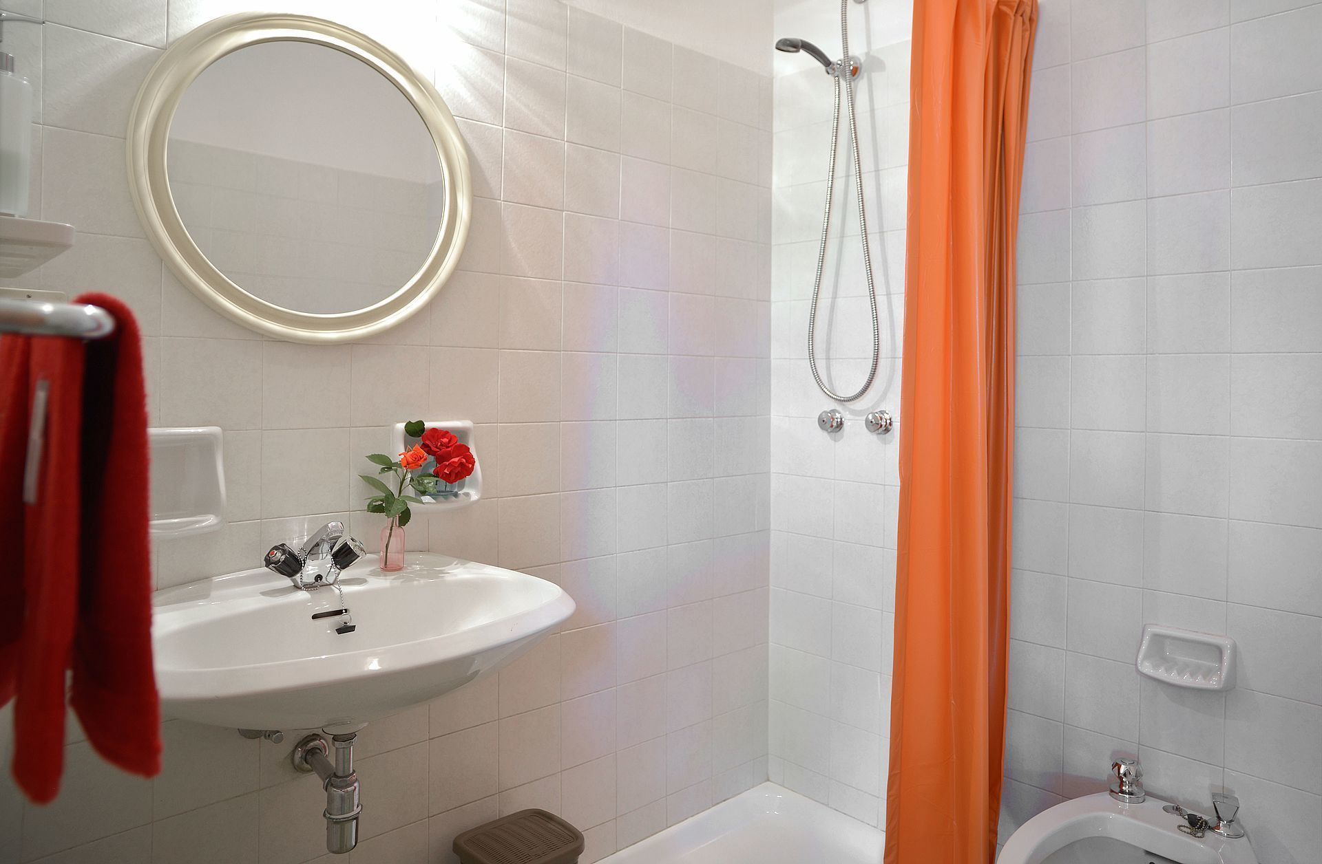 A bathroom with a sink, mirror, shower, and toilet.