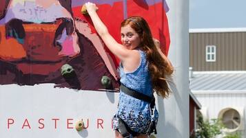 A person climbing a wall with a colorful mural.