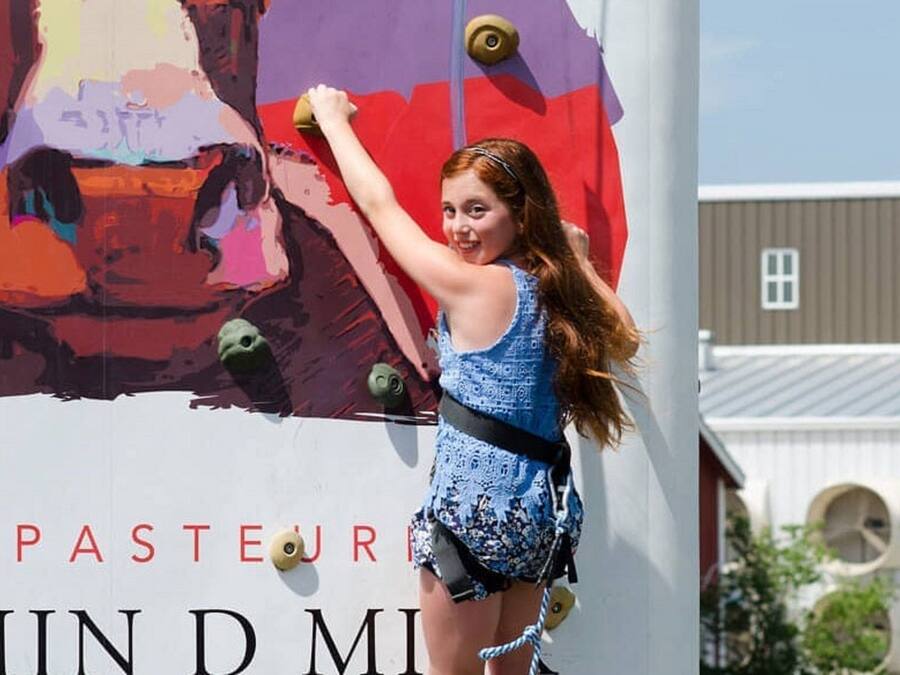 A person climbing a wall with a colorful mural.