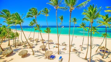 On the beach, white sand, sun loungers, beach umbrellas