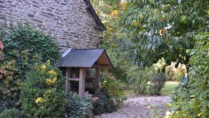 A stone building with a small wooden structure in front. - La Sévinais (Retiers)