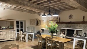 Una cucina rustica con travi a vista, un camino in pietra e un'area pranzo con mobili in legno.