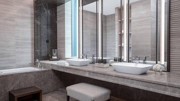 Une salle de bain moderne avec deux grands lavabos, un grand miroir et un petit banc.