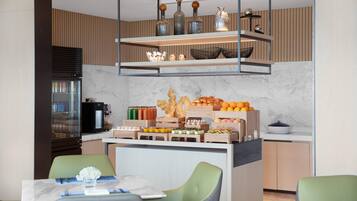 A modern kitchen with a marble countertop, wooden cabinets, and a built-in coffee station.