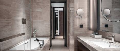A modern bathroom with a glass-enclosed shower, a large mirror, and a vanity with a sink.