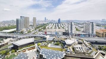 A high-rise building with a modern design, featuring a rooftop garden and solar panels.