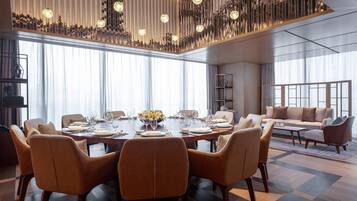 Un espace repas moderne avec une grande table ronde pouvant accueillir six personnes, entourée de chaises en cuir.
