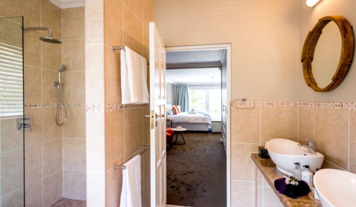 A bathroom with a shower, sink, and mirror.