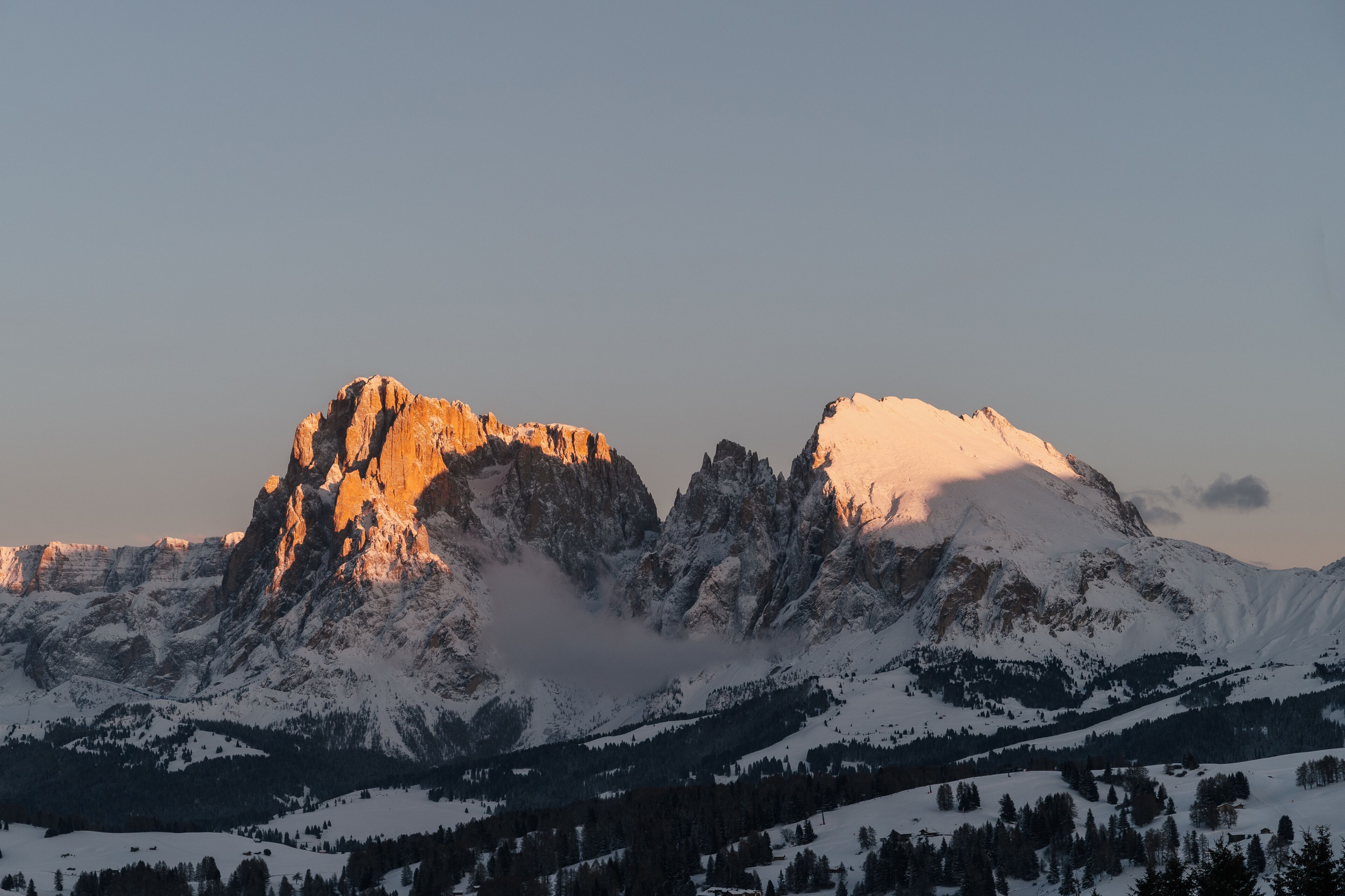 Un paysage montagneux aux sommets enneigés, sous un ciel dégagé.