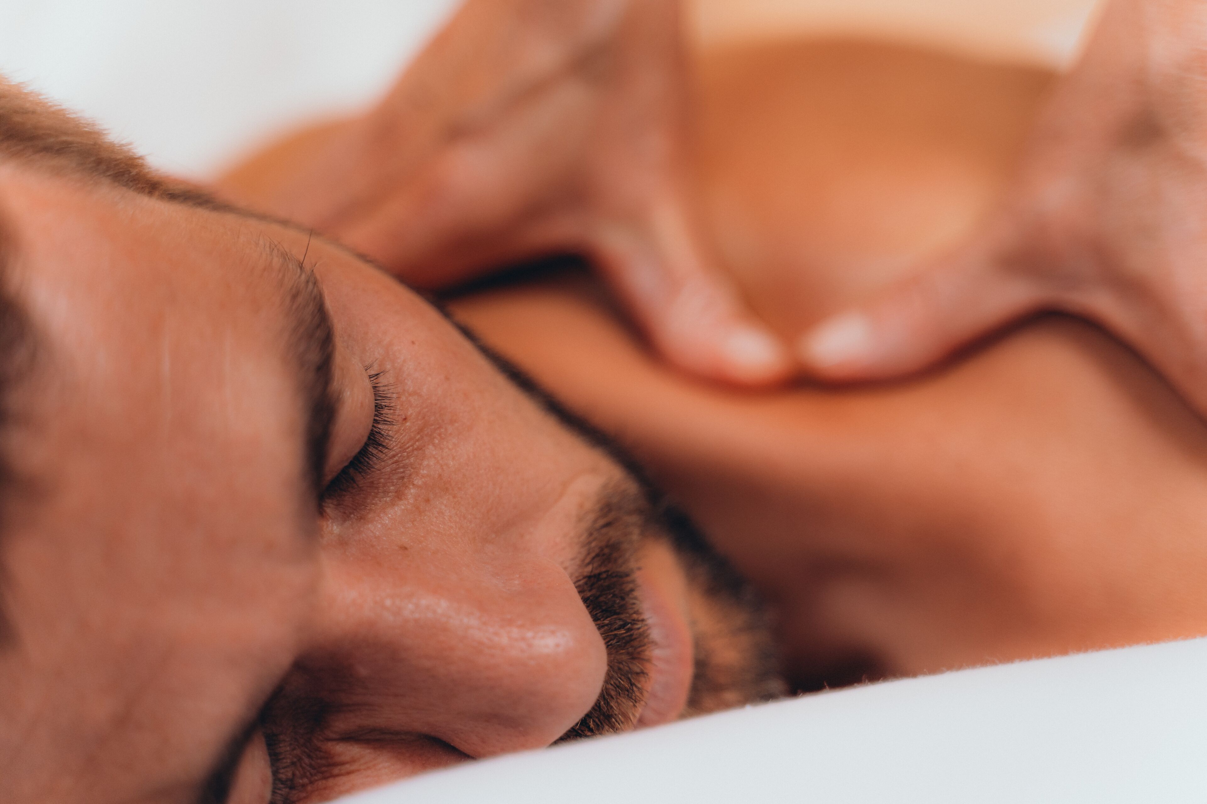 A close-up of a person's face resting on a white surface.