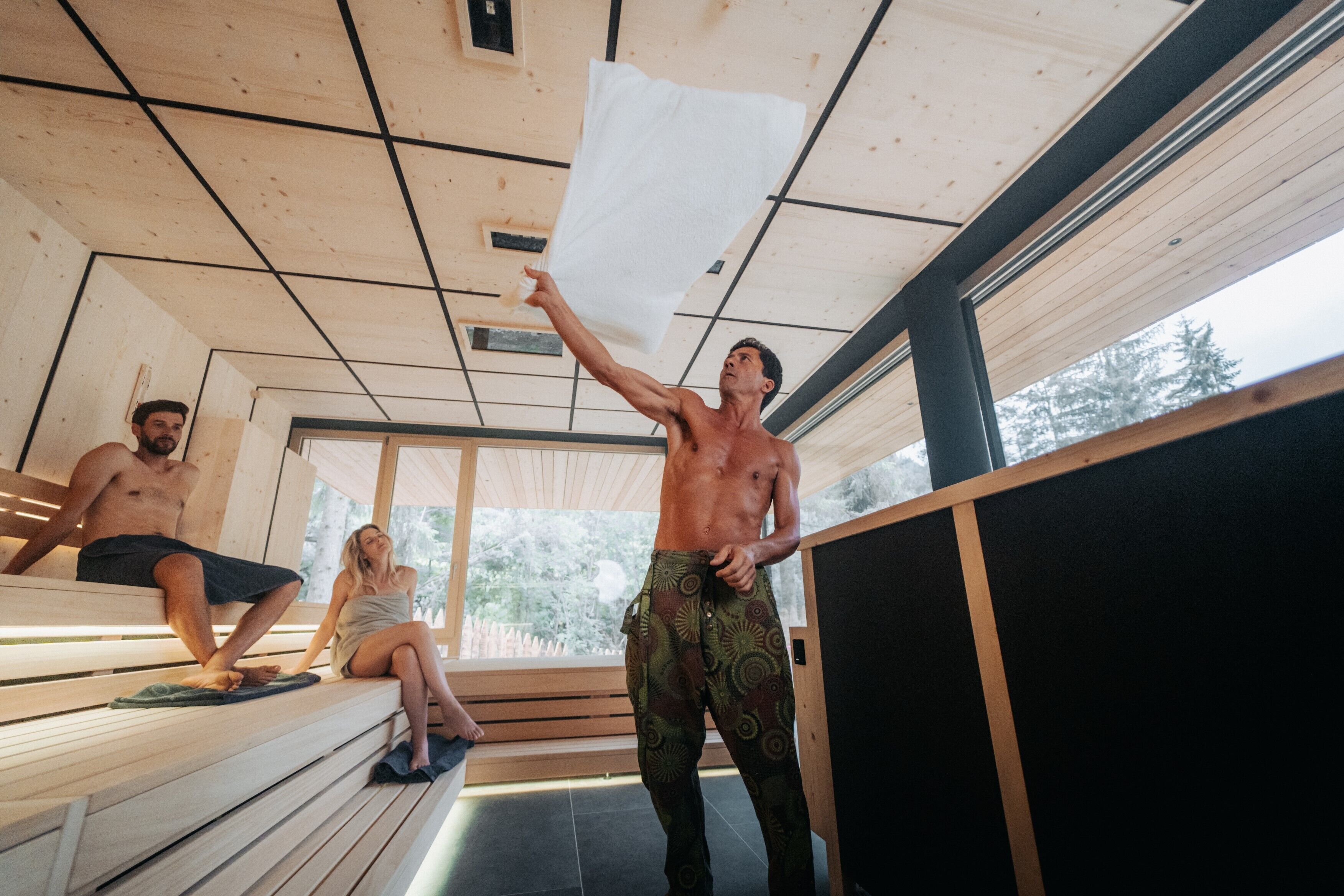A sauna with wooden benches and a high ceiling.