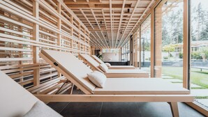A spa area with wooden loungers and a ceiling with a grid pattern. - Sensoria Dolomites (Castelrotto)