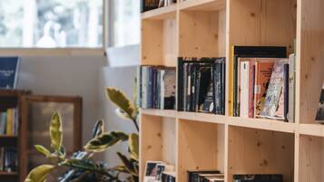 Una estantería llena de libros, una planta en maceta y un suelo de madera.