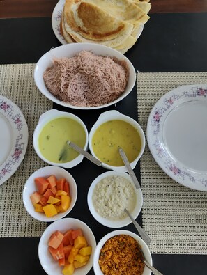 A table with various dishes including crepes, shredded meat, and several bowls of soup and rice. - Subhas Hotel (Jaffna)