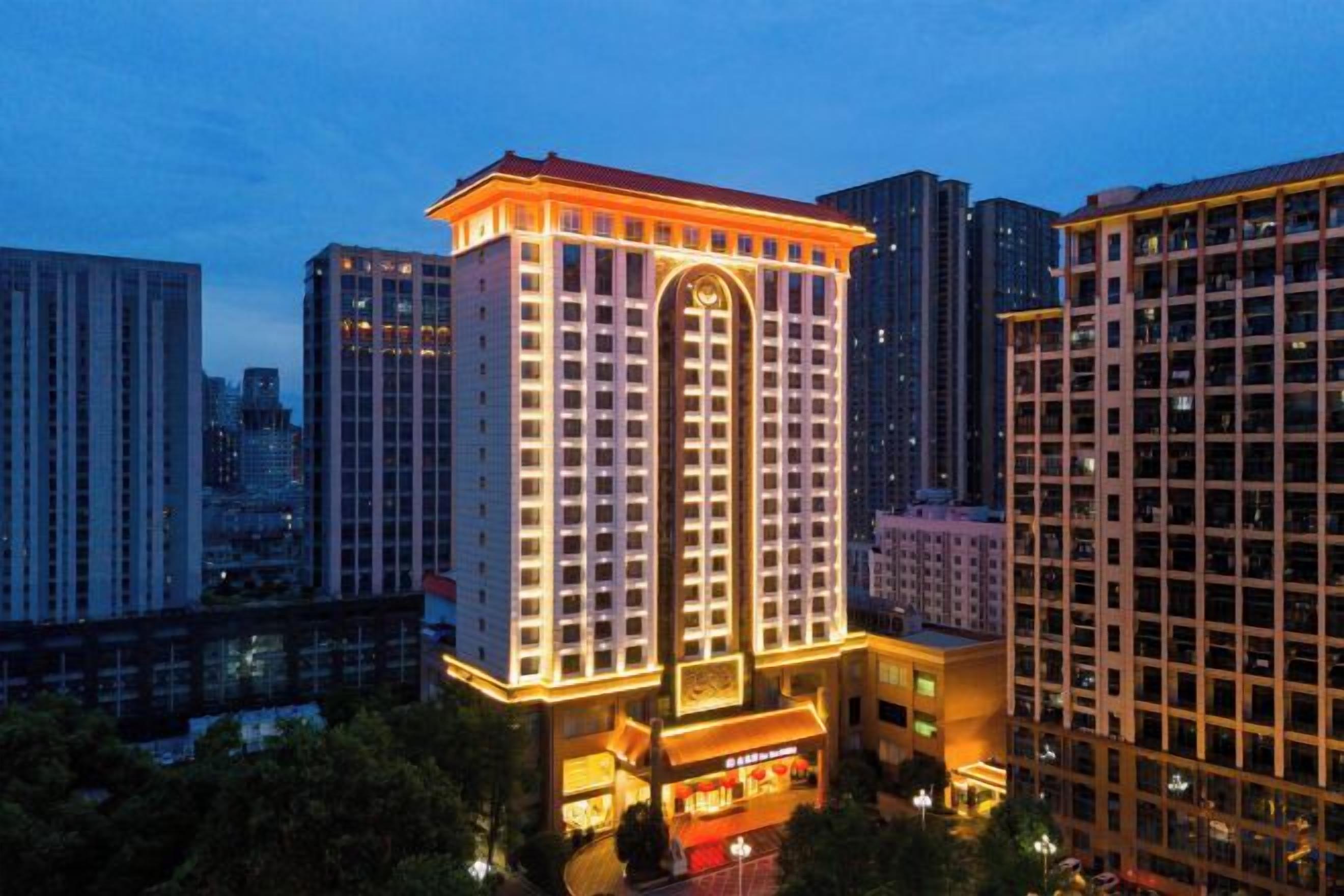 Un hotel de gran altura con una torre central destacada, rodeado de otros edificios.