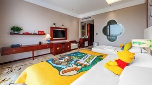 A hotel room with a bed, a TV, a desk, and a mirror.