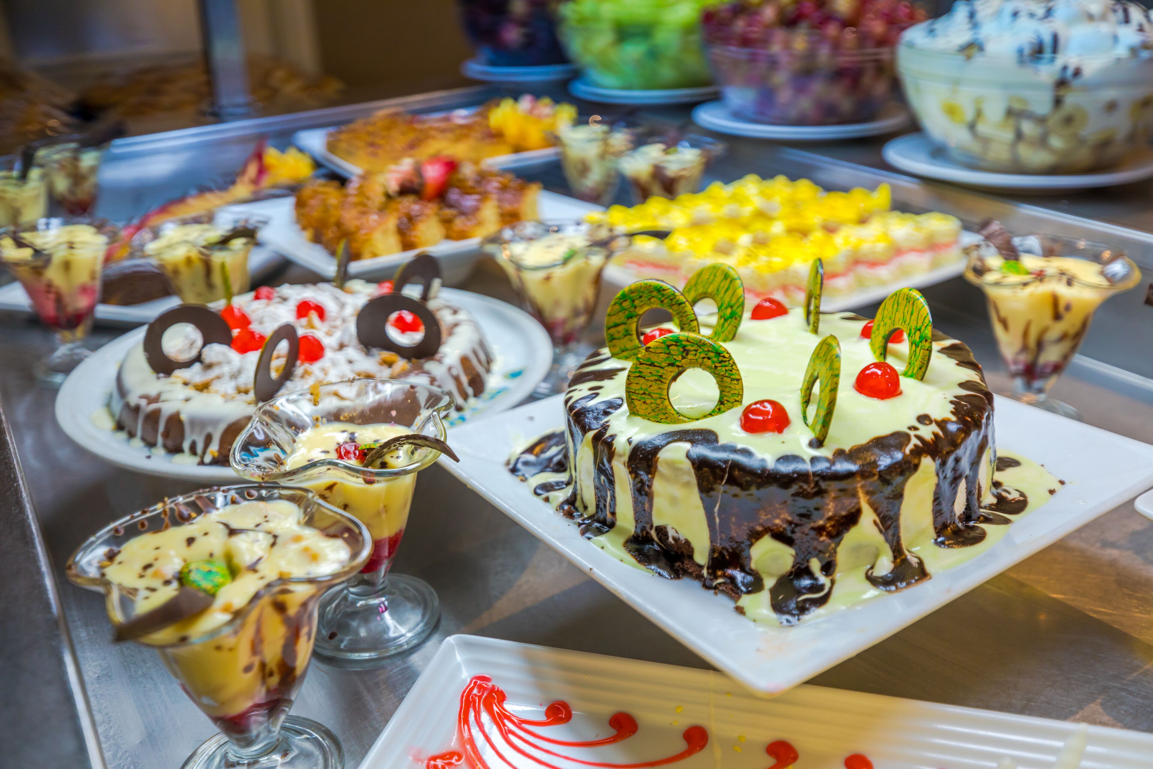 A variety of desserts on display, including cakes and fruit parfaits.