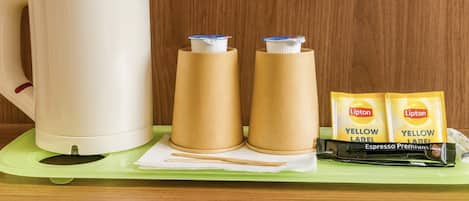 A kettle, two cups, and two packets of Lipton Larel Espresso Premium on a tray.
