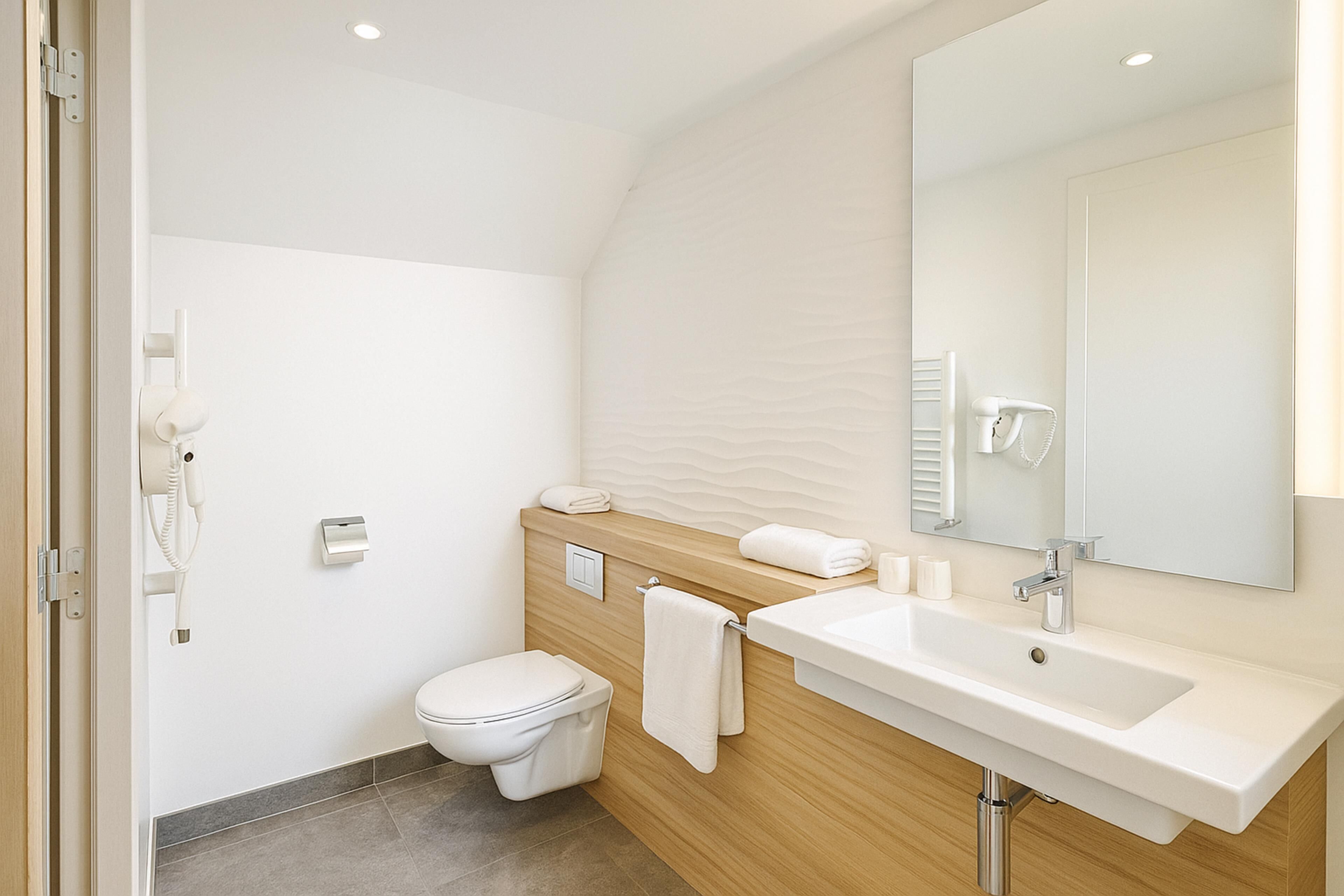 A modern bathroom with a toilet, sink, and towel rack.