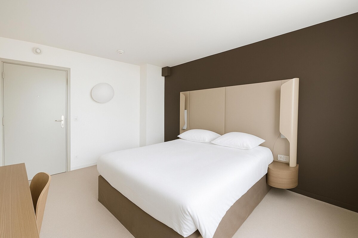 Un dormitorio moderno con una cama grande, una mesita de noche, una silla y una puerta.