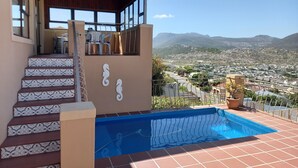 A residential property with a swimming pool, a staircase with patterned tiles, and a view of a town and mountains. - A Place in Thyme (Cape Town)