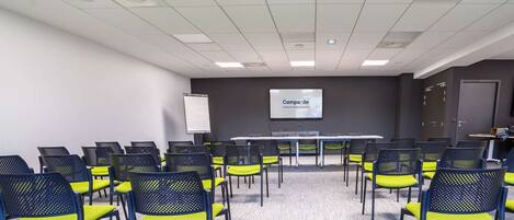 A conference room with a long table and chairs, a projector screen, and a whiteboard.