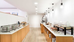 A modern kitchen with stainless steel appliances, wooden cabinets, and a long counter with food dispensers. - My City Hotel (Puerto de la Cruz)