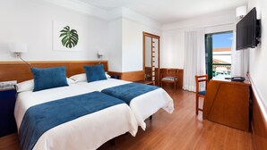 A hotel room with two beds, a desk, a chair, a television, and a view of the outside. - My City Hotel (Puerto de la Cruz)