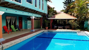 Una piscina al aire libre, sillones reclinables de piscina