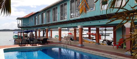 Una piscina al aire libre, sillones reclinables de piscina