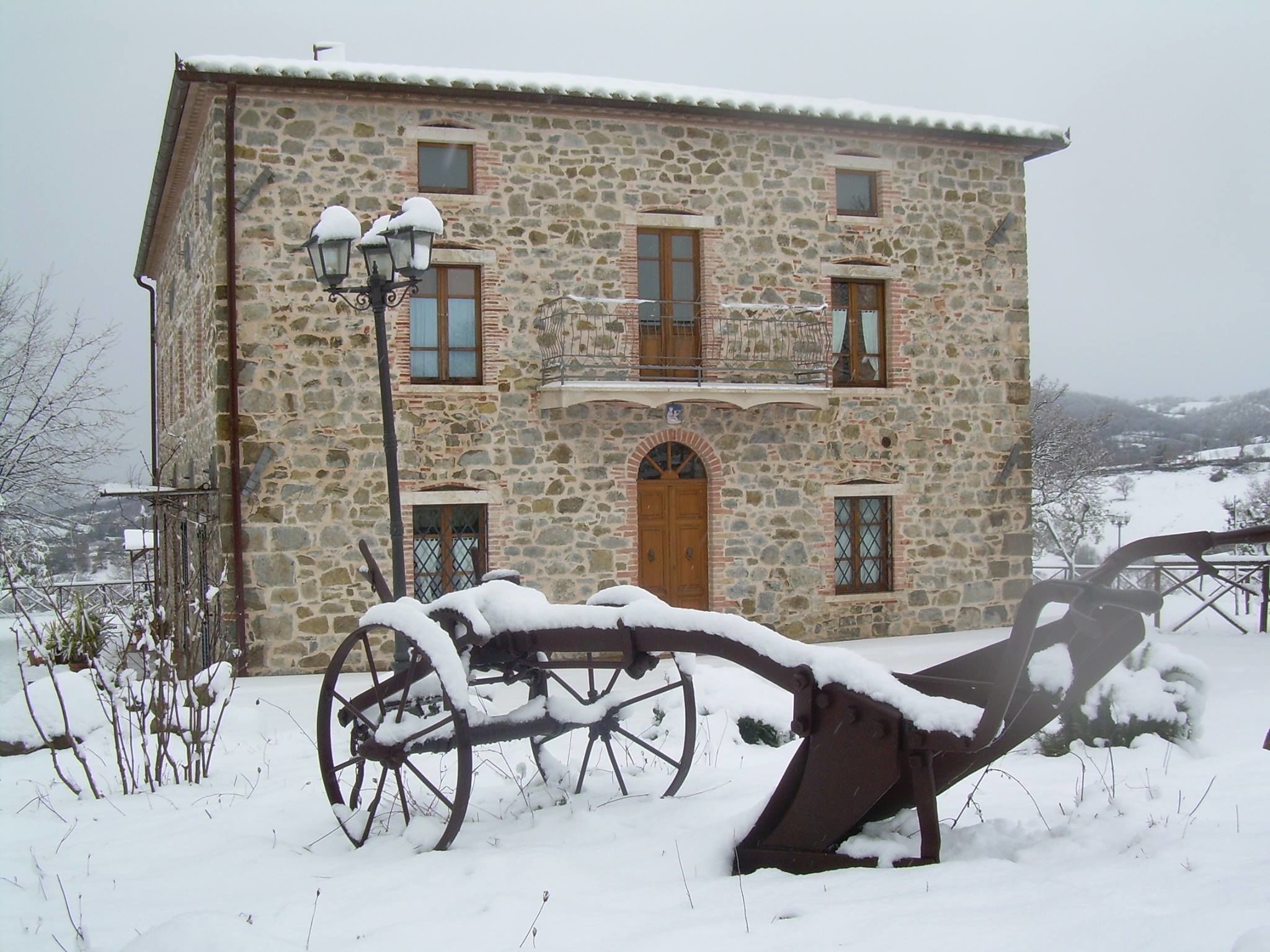 A stone building with a wooden door, windows, and a balcony.
