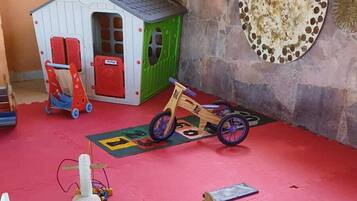 Children can play in the cozy playhouse with a wooden rocking horse and table.