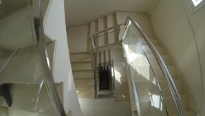 A modern interior with a glass staircase leading to a lower level. - Hotel Tamasite (Puerto del Rosario)